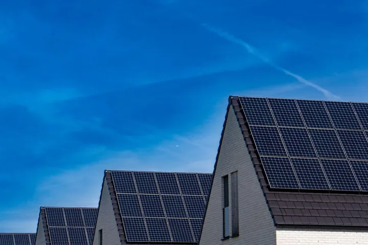 Casas geminadas com painéis fotovoltaicos no telhado sob céu azul