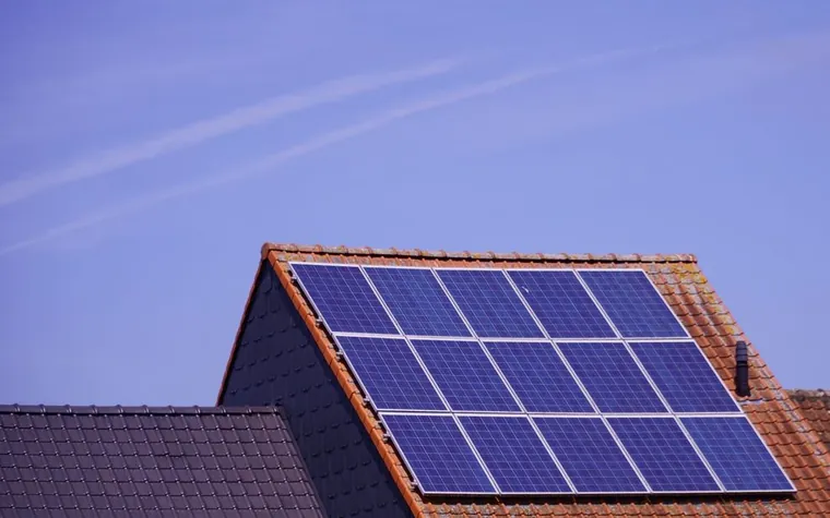 Painéis solares sobre telhado de telha cerâmica sob céu limpo