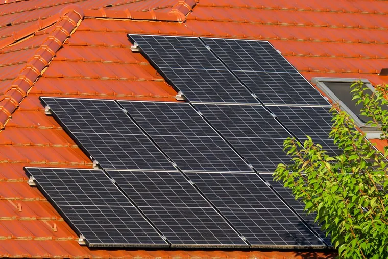 Painéis solares sobre telhado de telha cerâmica vermelha