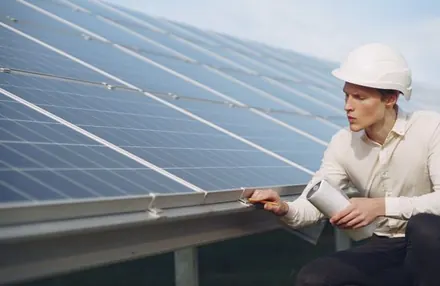 Engenheiro com capacete registrando a vistoria final do sistema solar